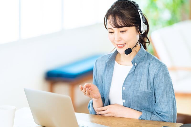 カフェのような明るい空間でノートPCを開きオンライン受講する女性