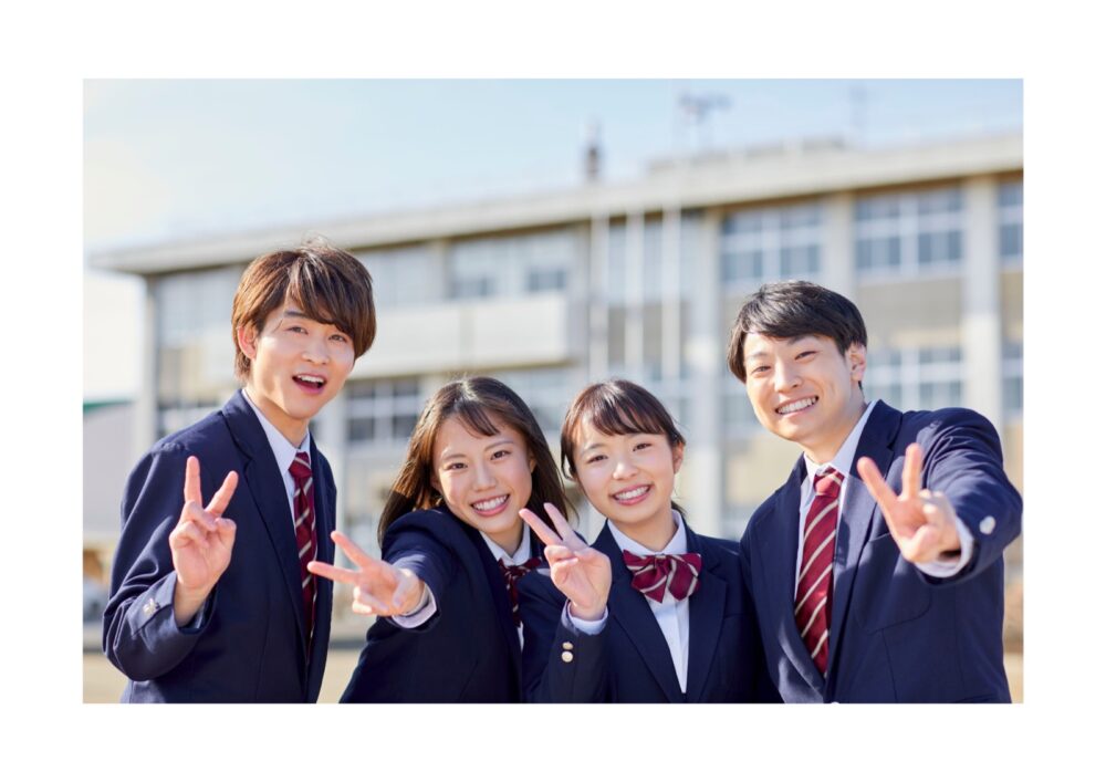 制服姿の高校生4人が笑顔で並ぶ集合写真